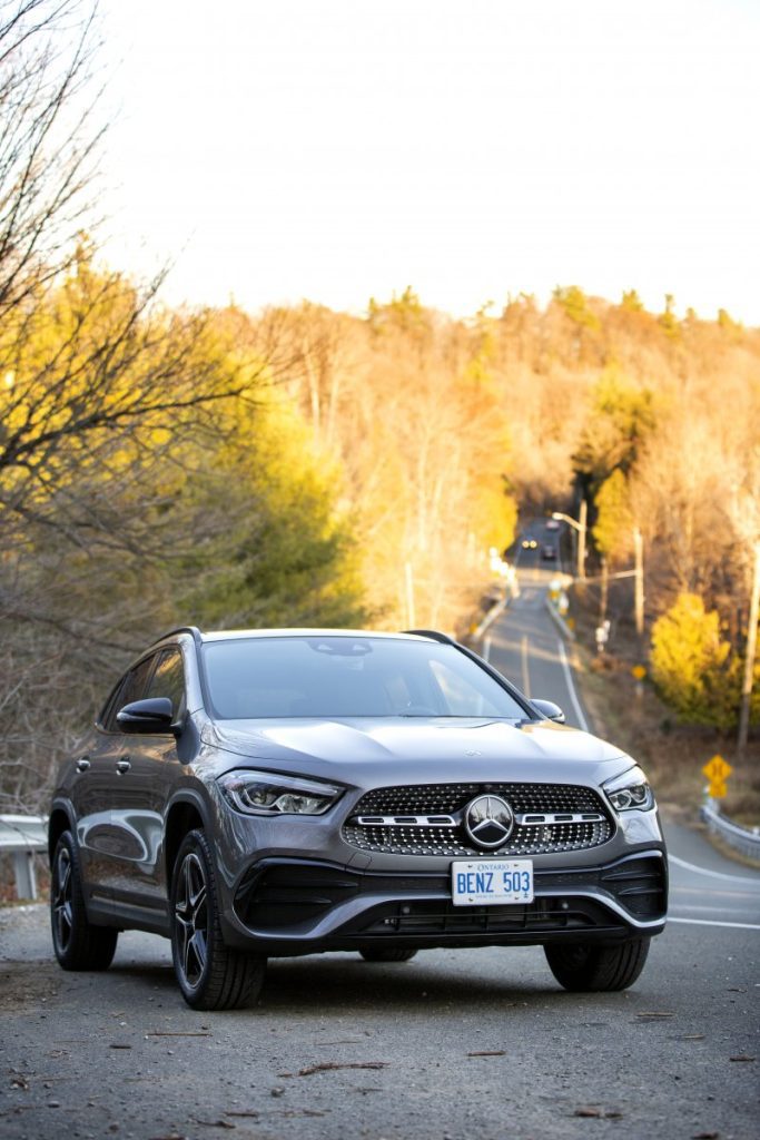 Mercedes Benz GLA parked on road with forest backdrop