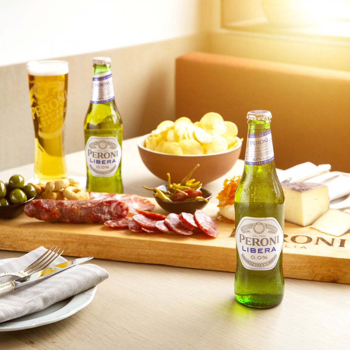 Board of assorted meats and cheeses accompanied by Peroni Libera a new non-alcoholic beer.