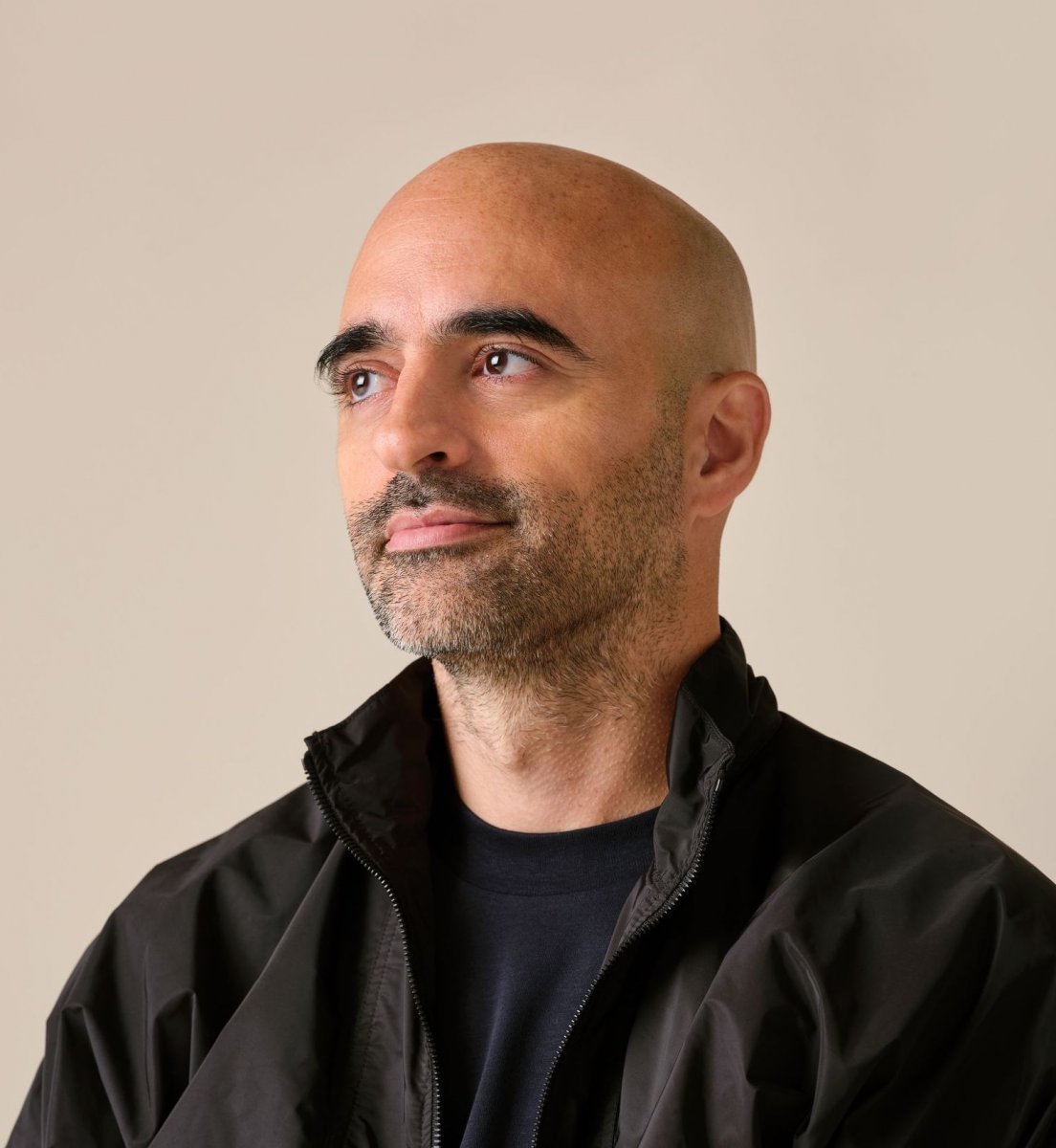 SSENSE CEO Rami Atallah looking pensive and off camera wearing black jacket and t-shirt