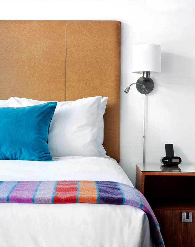 Motel room with white linens and colourful blanket