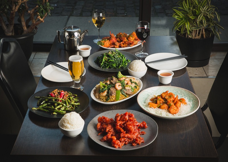 Dishes from Hong Shing's menu displayed on a black table