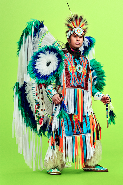 Notorious Cree in traditional Indigenous regalia against green background