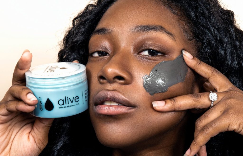 Young woman putting on the Dew of the Gods Alive Detox Mask