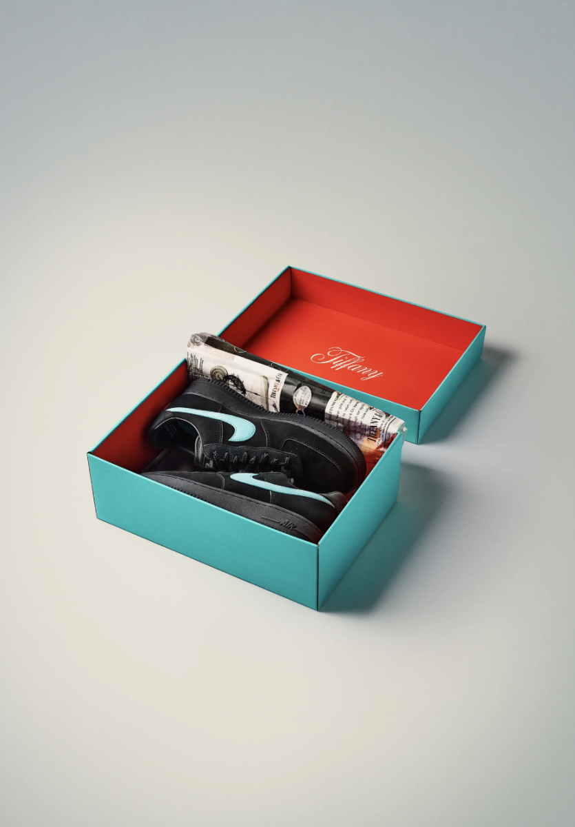 Black Nike sneakers with blue swoosh in a blue box