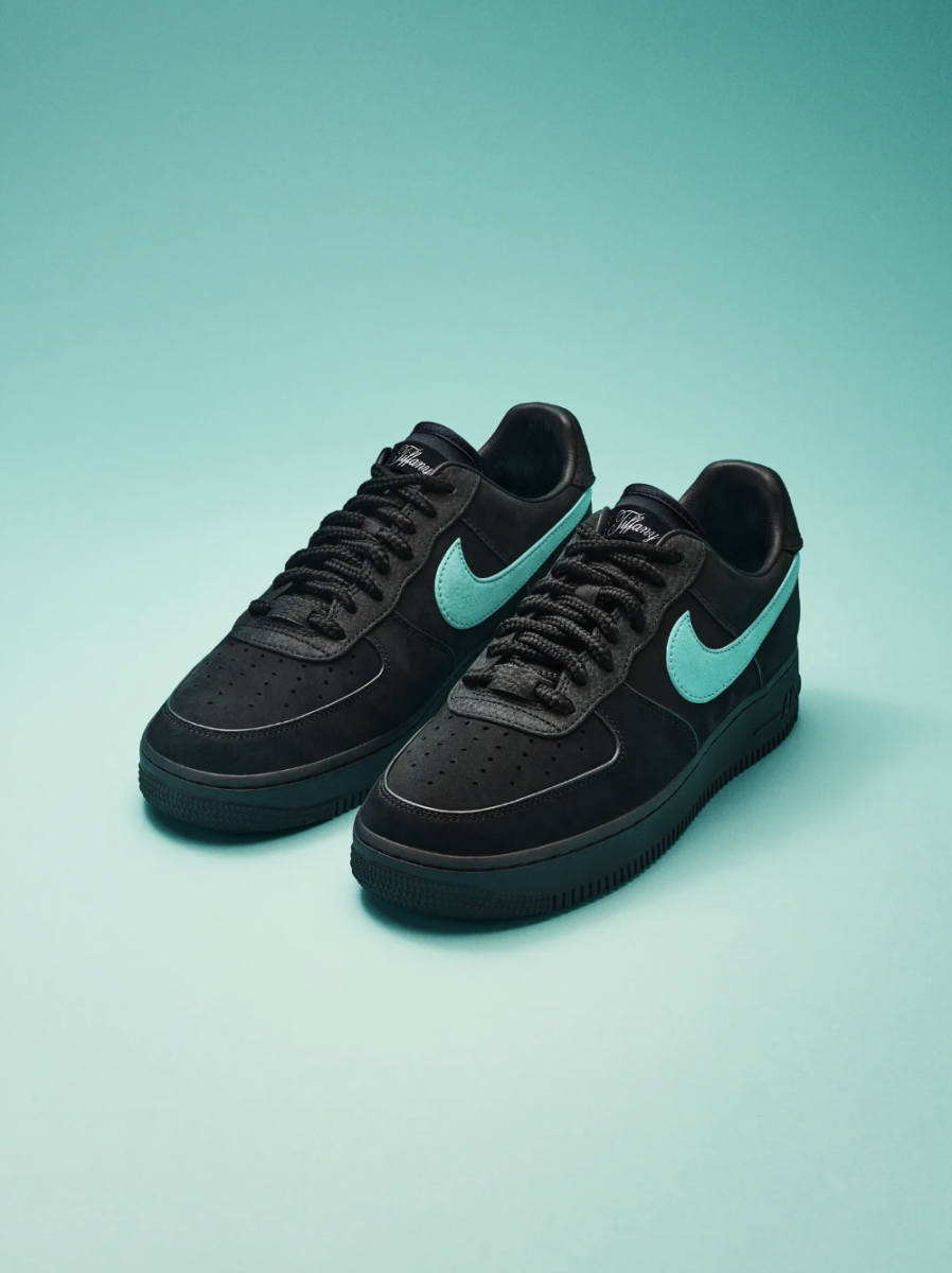 Black Nike sneakers with blue swoosh on blue background
