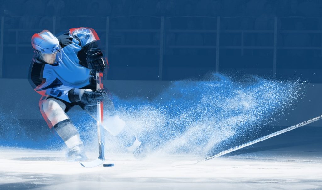 Ice hockey player handles puck on an ice rink.