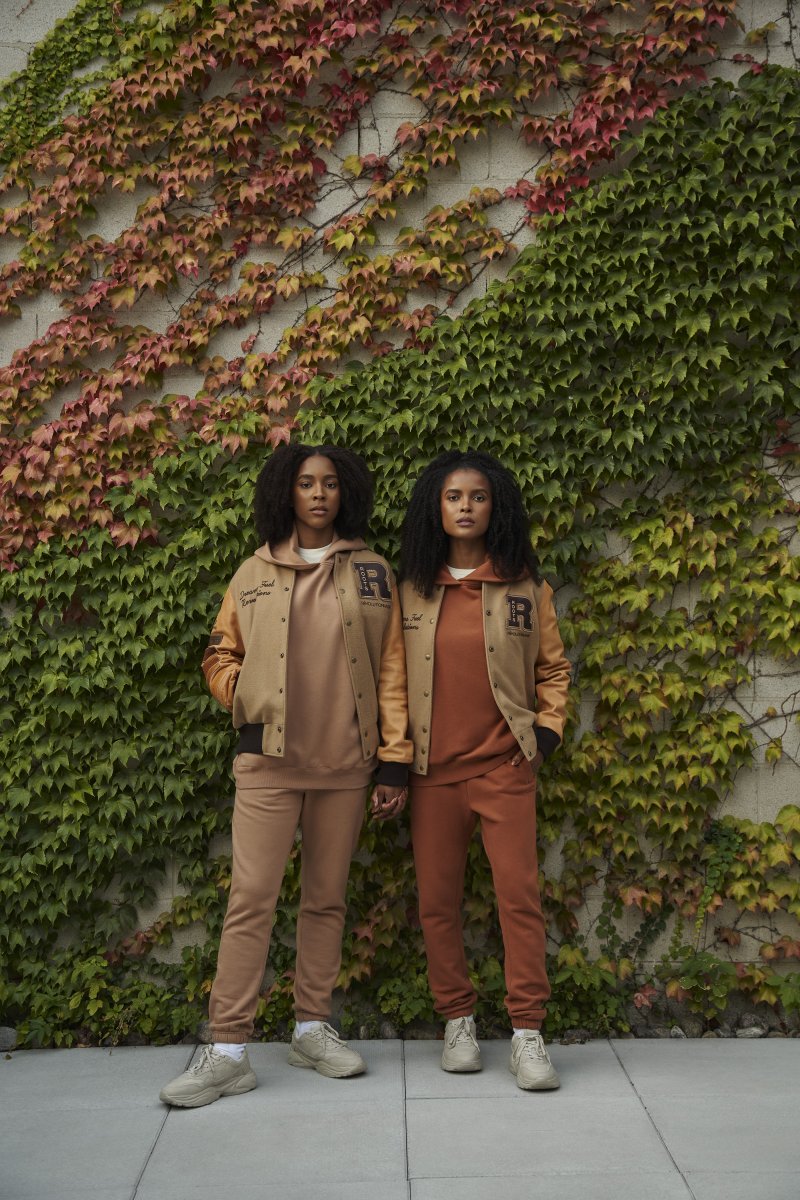 Two women standing against wall with ivy