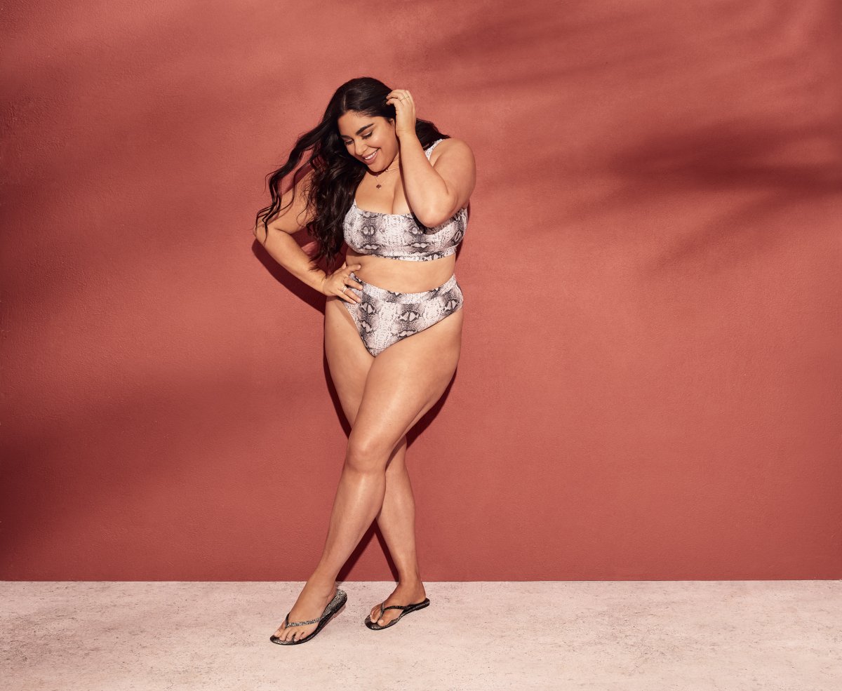 Roxy Earle poses in front of a pink wall wearing a snake print bikini from her Joe Fresh collection.