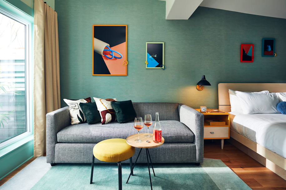 Colourful motel room with couch and wine on table