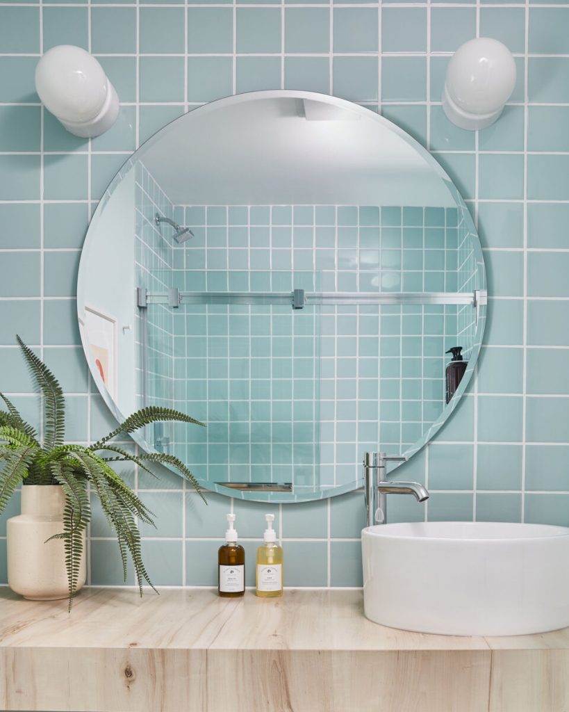 Motel bathroom with blue tiles and plant