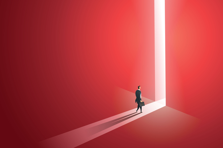 Businessman walking go to front of bright big shining door in the wall red of the hole at light falls