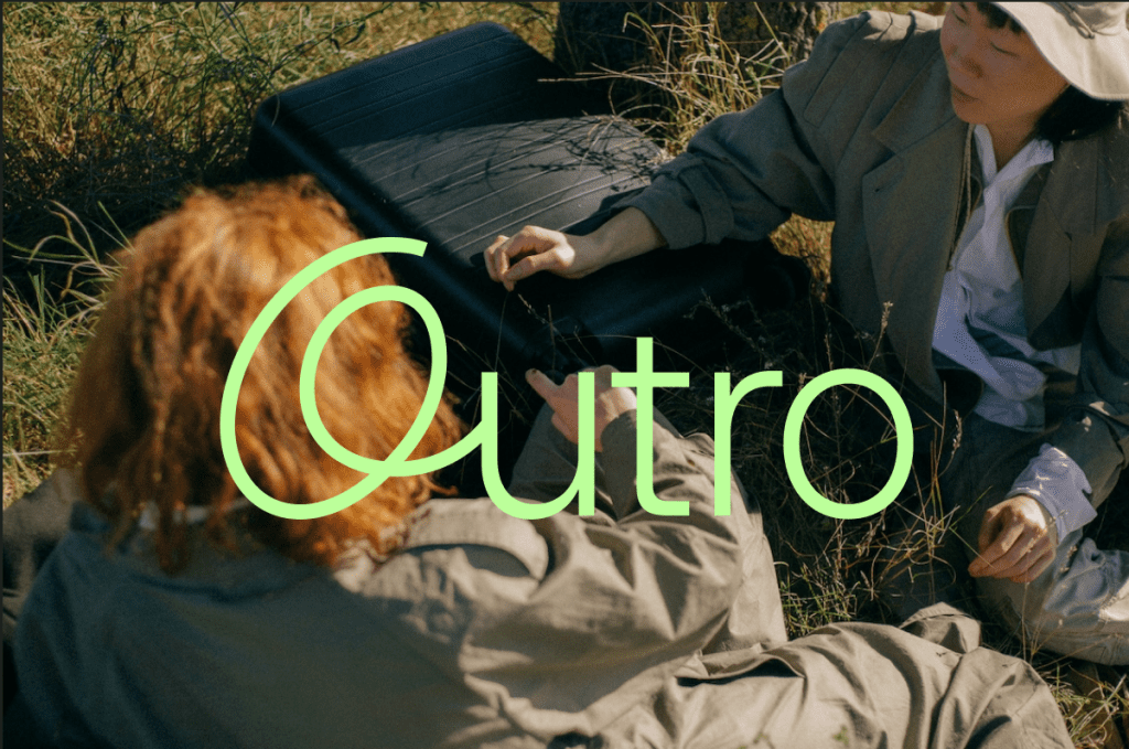Photo of two people sitting in a grassy field. The logo for the Antidepressant tapering company Outro is superimposed on the image.