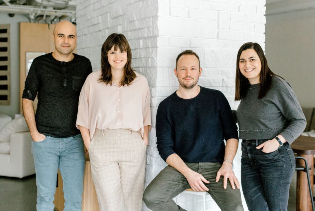 Sundays Furniture founders standing against a white brick wall.