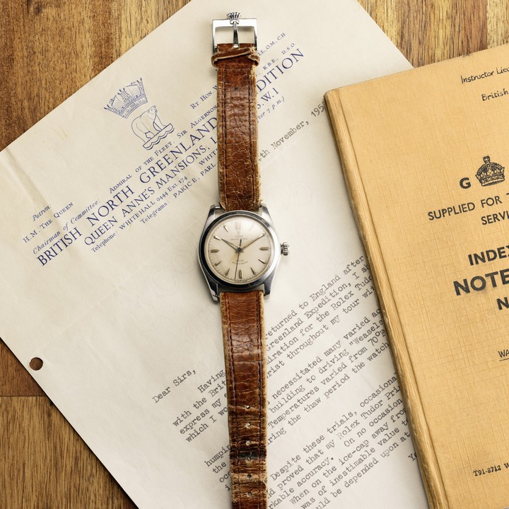 Vintage TUDOR watch with a faded glass cover and aged brown leather straps. It is set against a sheet of paper with expedition notes and a journal.