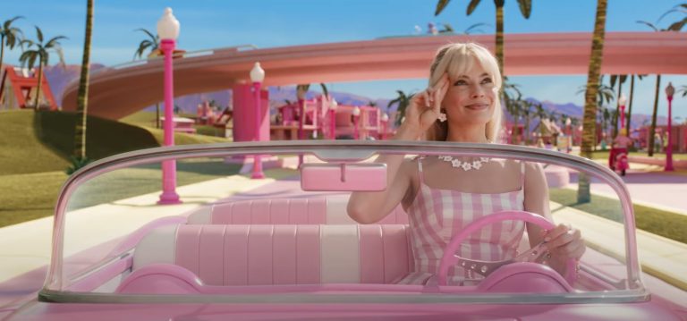 Image of Barbie driving down the street of Barbie Land in her pink car.
