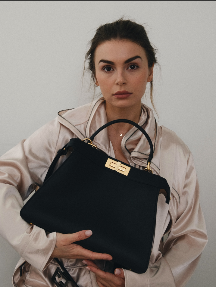 Photo of women displaying a large black purse.