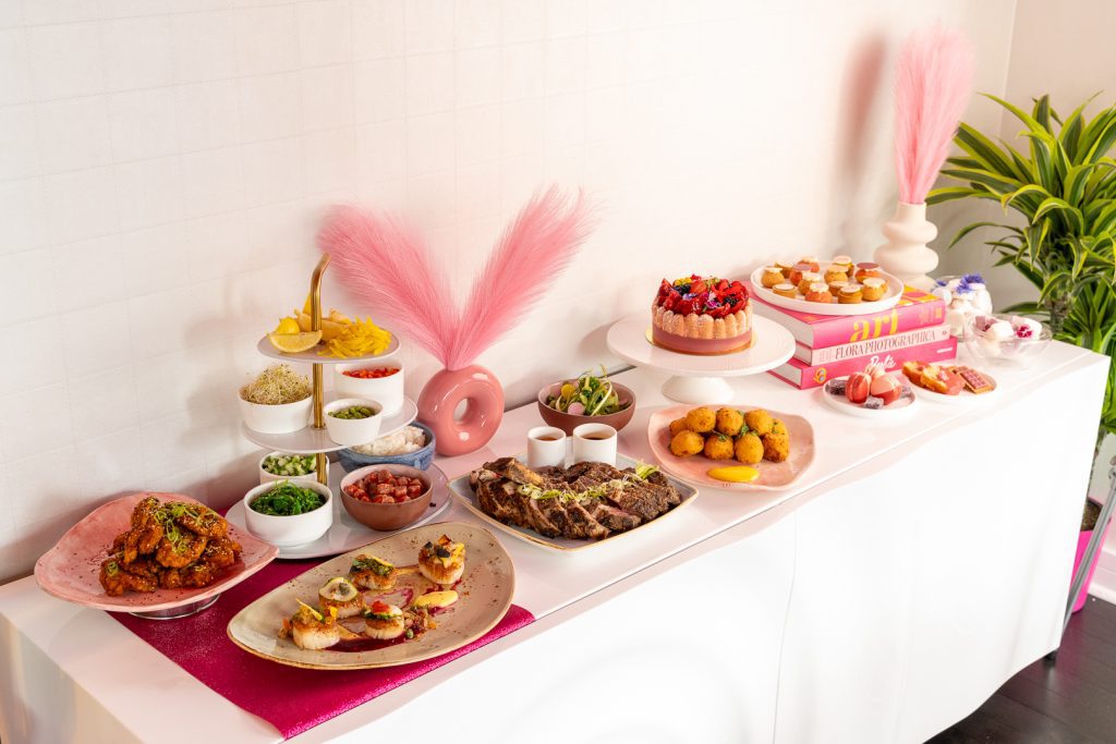 Photo of a wonderful display of food from the Barbie Dream Experiences. There are cakes, scallops, salads, and more.