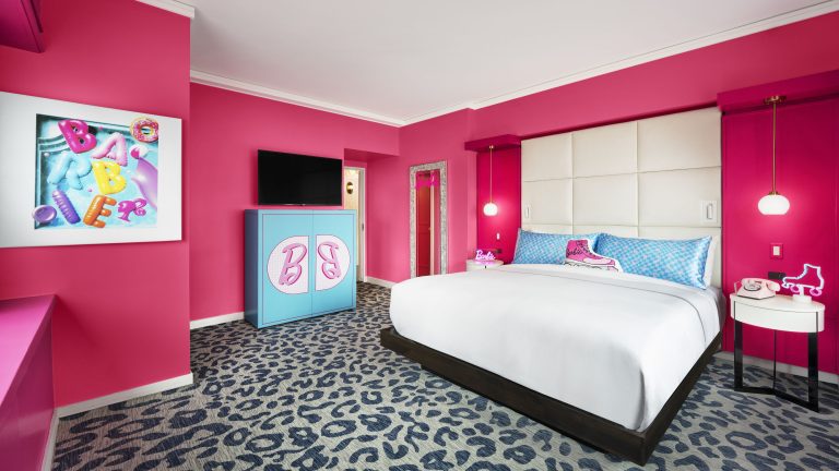 Photo of the "Barbie Dream Suite" (Bedroom 1) at the Barbie Dream Experiences. All the walls are Barbie Pink, and there is a collection of Barbie themed furniture that decorates the room.