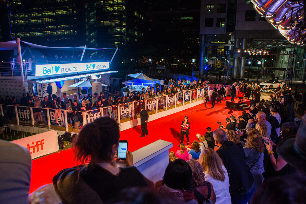 TIFF red carpet filled with celebrities walking and a crowded audience.