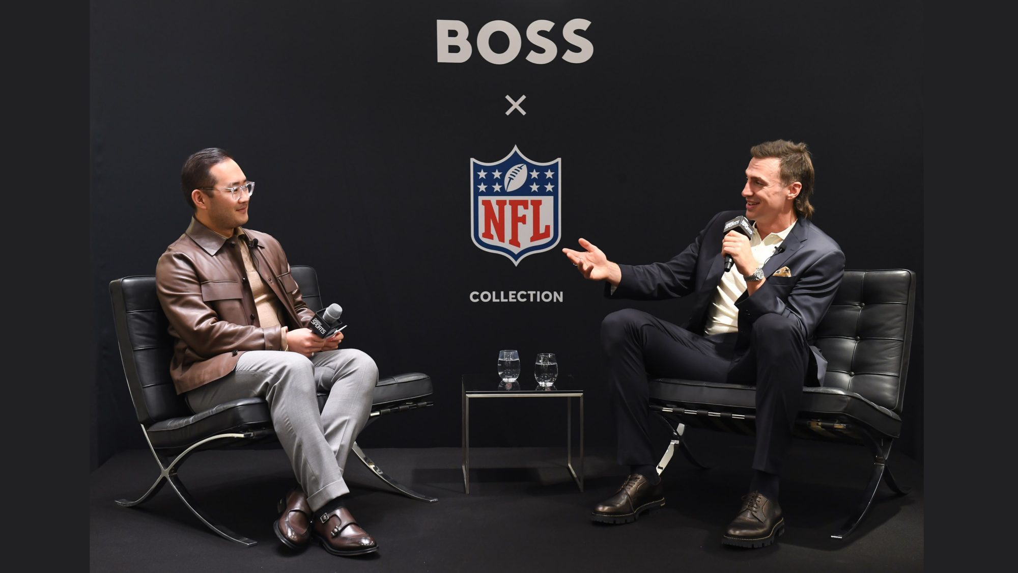 GLORY Sports Editor Lance Chung is seated on a stage sitting opposite former NFL pro Luke Willson with a BOSS and NFL backdrop as they speak in a Q&A together.