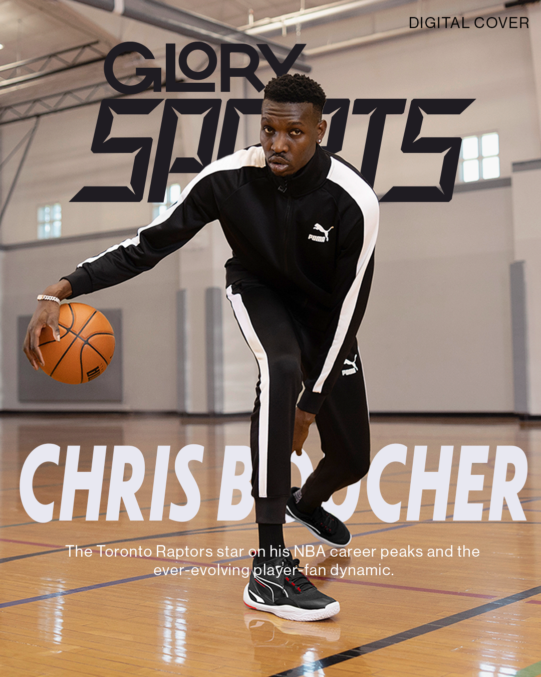 Chris Boucher is dribbling the ball and facing the camera. He is wearing a black track suite with white stripes down the arm and legs. He is wearing black sneakers on a basketball court.