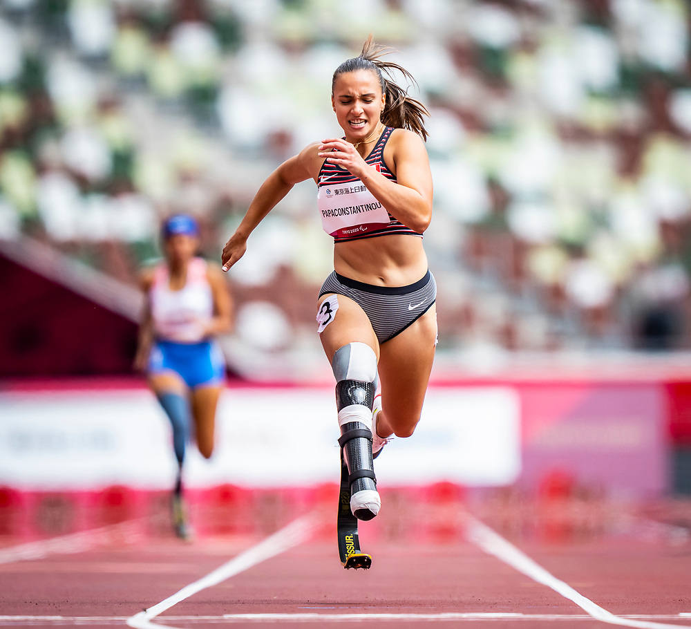 Paralympian Marissa Papaconstantinou in her running gear and blade running down a track.